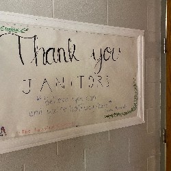 A poster reading "Thank you Janitors" is hung up outside Tim Clark's office